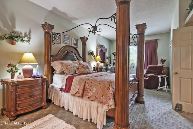 bedroom featuring carpet flooring, ornate columns, and a textured ceiling