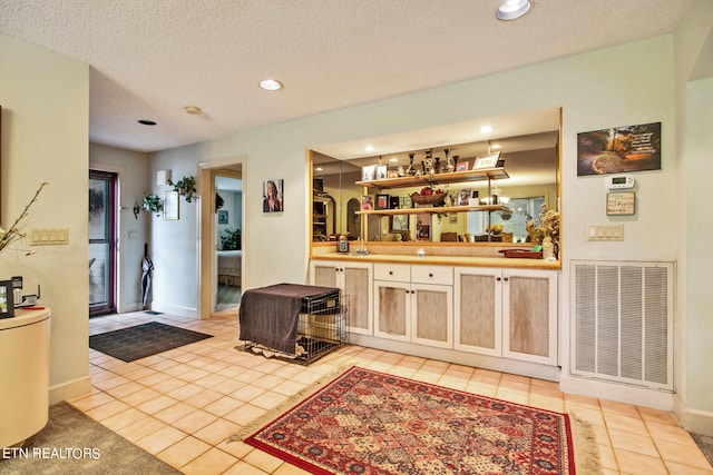 interior space with a textured ceiling and light tile patterned flooring