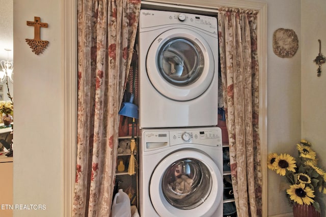 laundry room with an inviting chandelier and stacked washer / drying machine