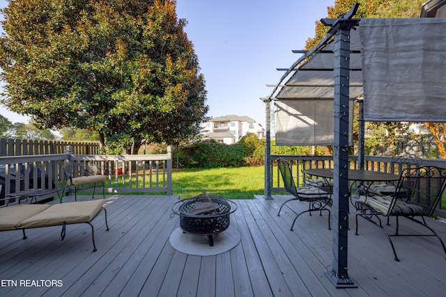 deck featuring a lawn and a fire pit