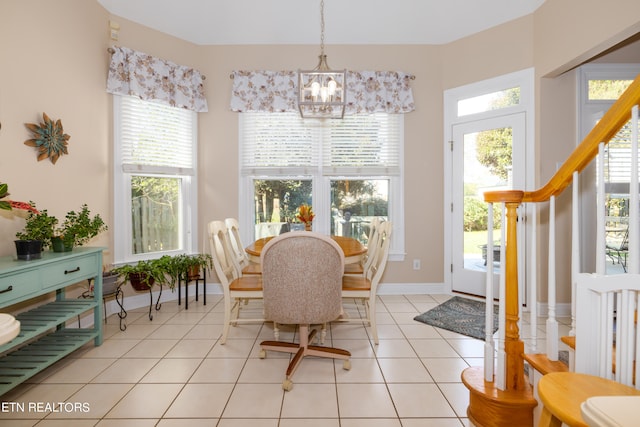 tiled dining area with a chandelier and a wealth of natural light