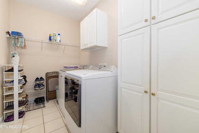 laundry area with cabinets, washer and clothes dryer, and light tile patterned floors