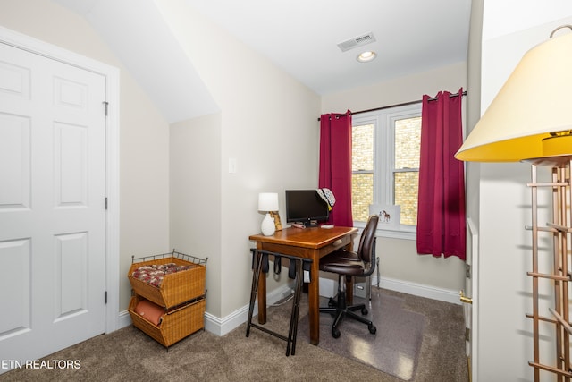 office space with vaulted ceiling and dark colored carpet