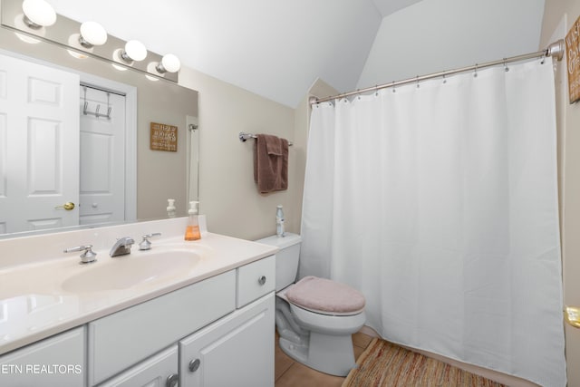 bathroom featuring vanity, lofted ceiling, toilet, and tile patterned floors