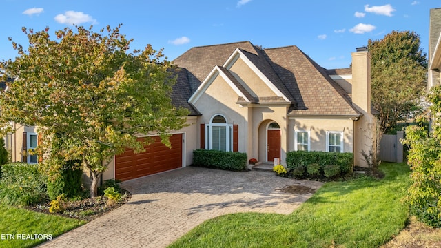 view of front of house with a front yard and a garage