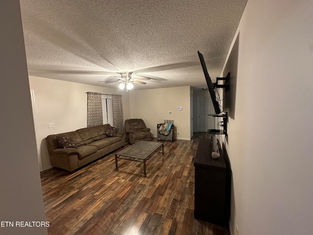 living room featuring ceiling fan, a textured ceiling, and dark hardwood / wood-style floors