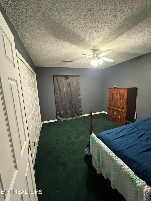 carpeted bedroom with a closet, a textured ceiling, and ceiling fan