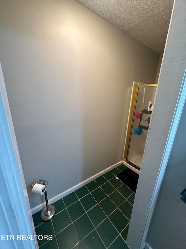 laundry room featuring a textured ceiling and dark tile patterned flooring