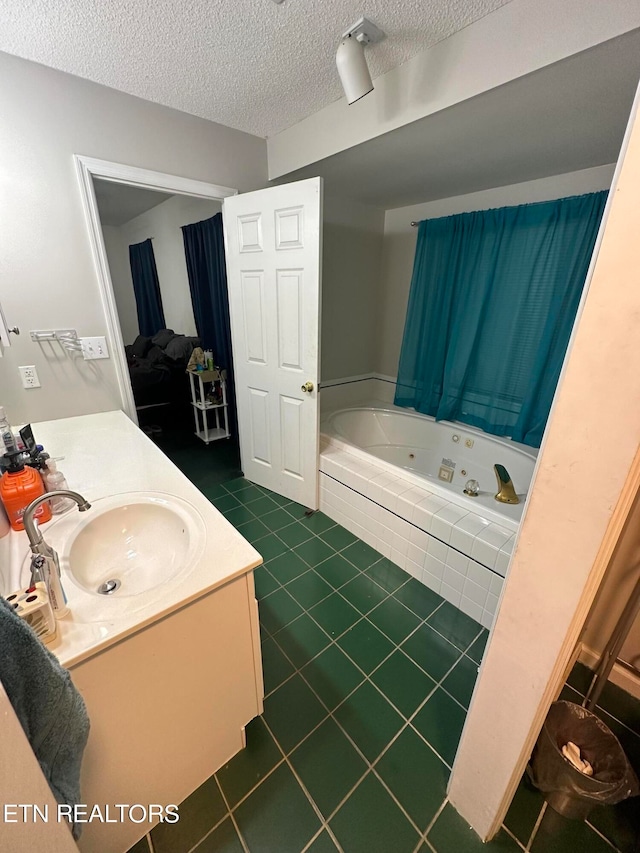 bathroom featuring vanity, a textured ceiling, tiled tub, and tile patterned floors