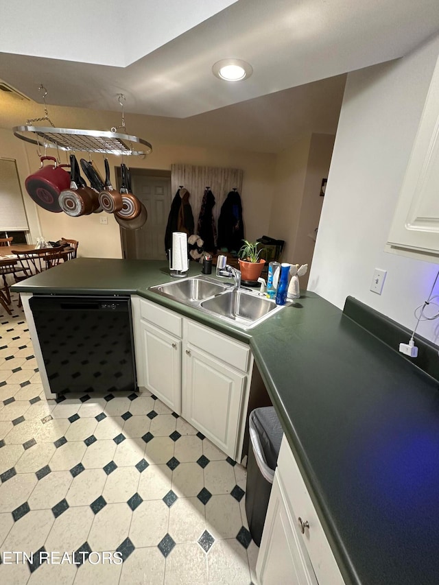 kitchen with white cabinetry, black dishwasher, and sink