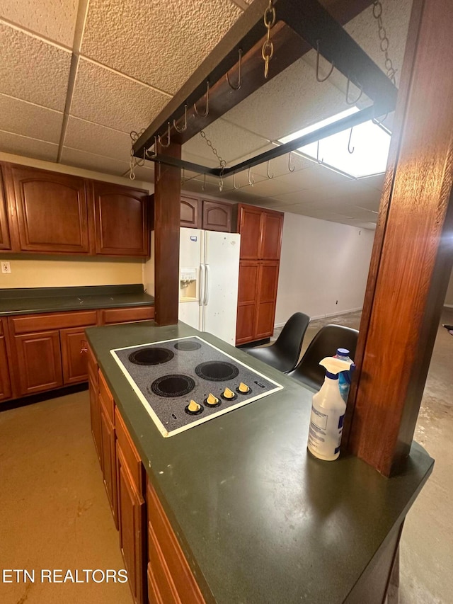 kitchen with white refrigerator with ice dispenser and electric cooktop