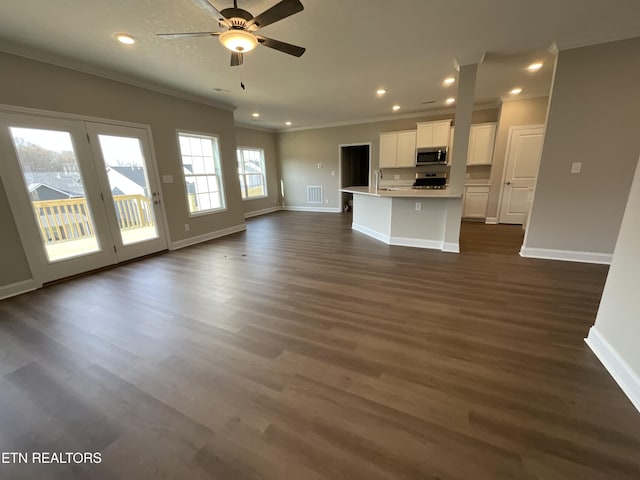 unfurnished living room featuring sink, crown molding, dark hardwood / wood-style floors, and ceiling fan