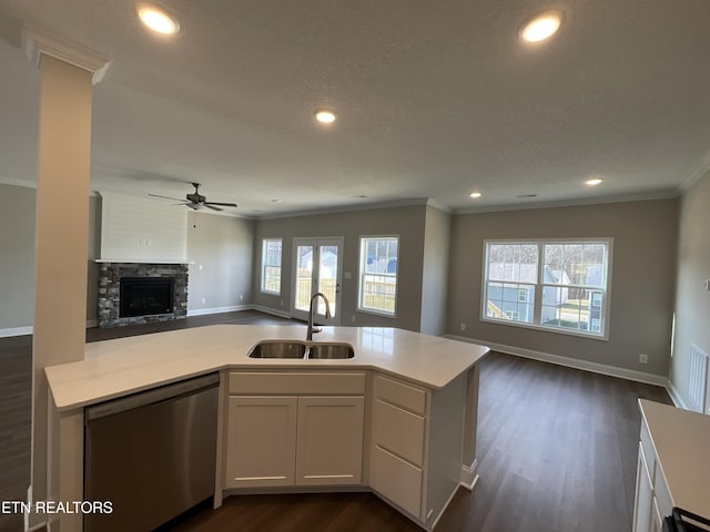 kitchen featuring sink, dishwasher, a kitchen island with sink, ornamental molding, and white cabinets