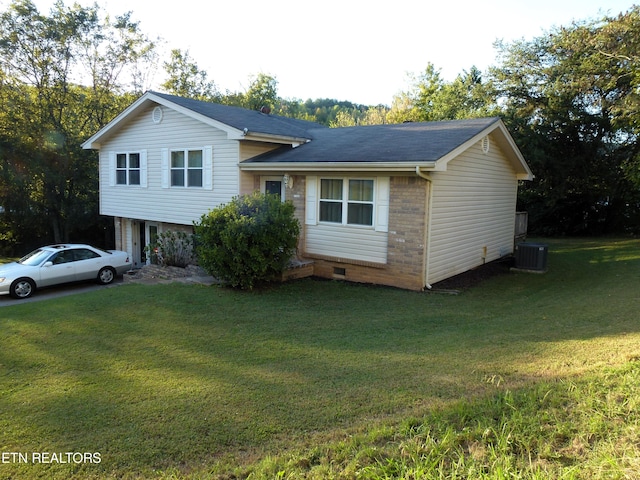 tri-level home with a front yard and cooling unit