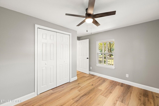 unfurnished bedroom with light wood-type flooring, ceiling fan, and a closet