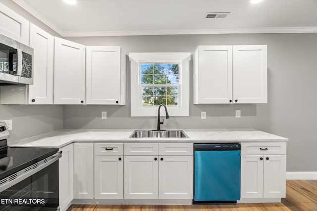 kitchen with light hardwood / wood-style floors, white cabinetry, sink, and stainless steel appliances