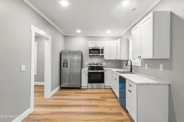 kitchen with light wood-type flooring, white cabinetry, sink, and stainless steel appliances