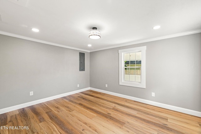 spare room featuring electric panel, crown molding, and hardwood / wood-style floors