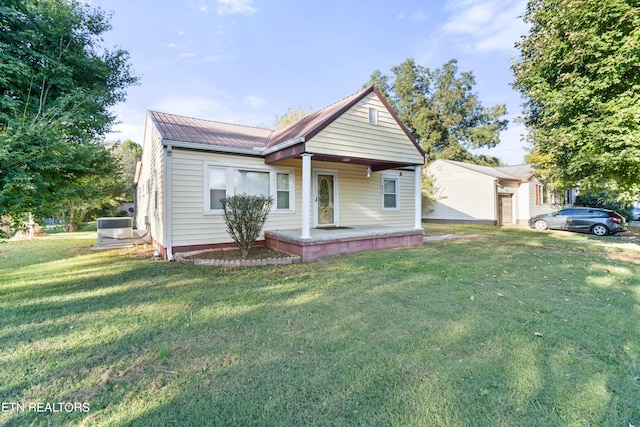 bungalow-style home with a front lawn and central air condition unit