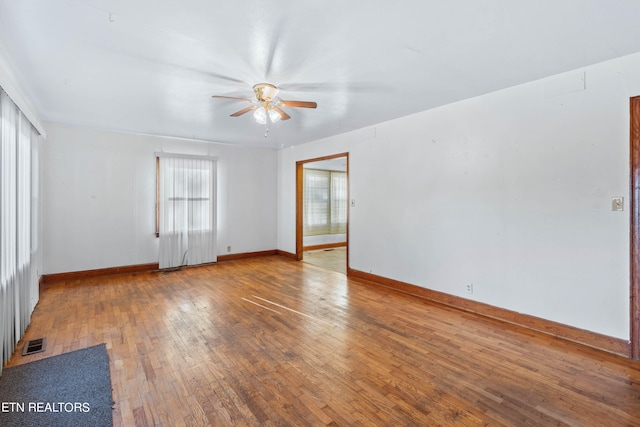 empty room with hardwood / wood-style floors and ceiling fan