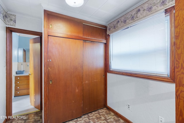 unfurnished bedroom with a closet, light parquet floors, and ornamental molding