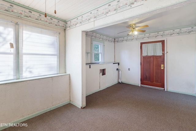 carpeted empty room with a healthy amount of sunlight, ceiling fan, and wooden ceiling