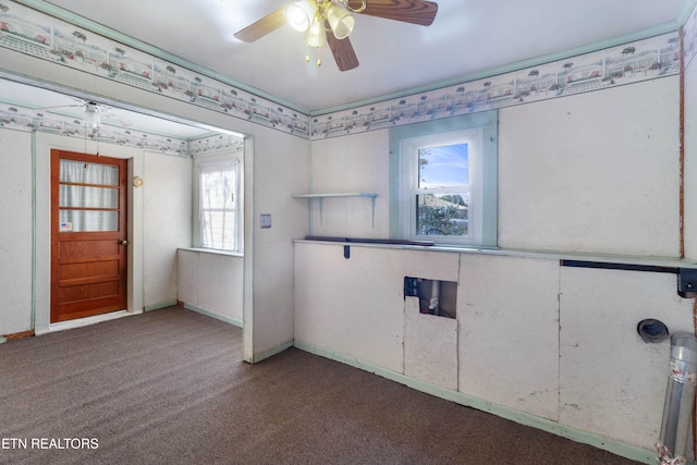 spare room with dark carpet, a wealth of natural light, and ceiling fan