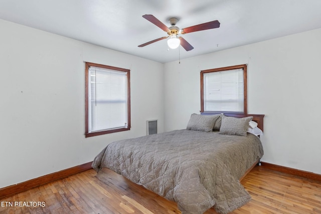 bedroom featuring light hardwood / wood-style flooring, multiple windows, and ceiling fan