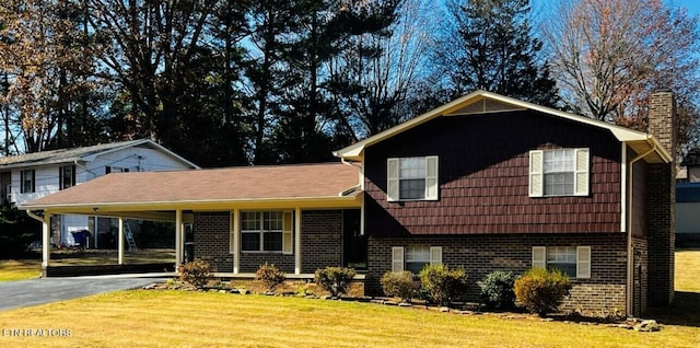 tri-level home with a carport and a front lawn