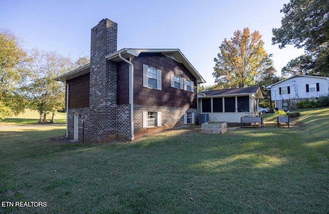 rear view of property with a yard and a sunroom