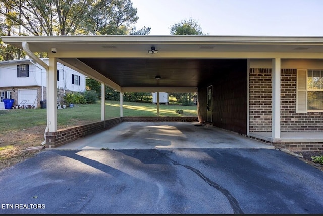 view of vehicle parking with a yard and a carport