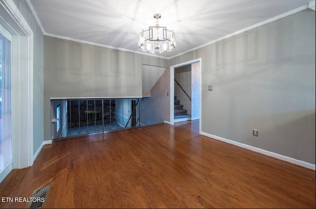 unfurnished living room featuring ornamental molding, a chandelier, hardwood / wood-style flooring, and a textured ceiling