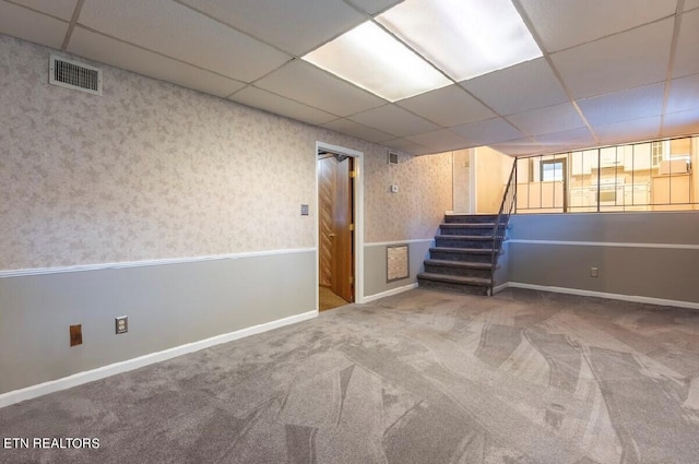 basement featuring a drop ceiling and carpet floors