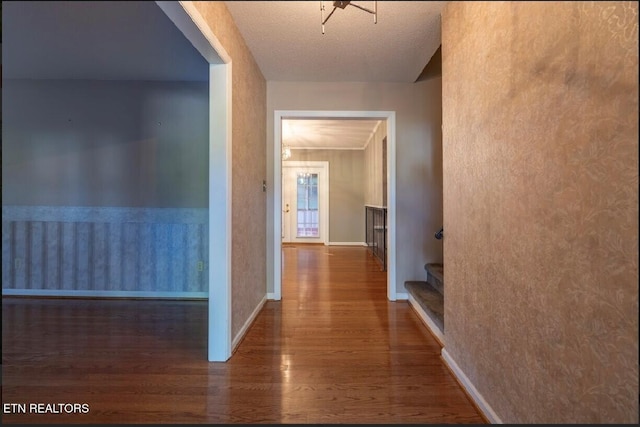 hall with a textured ceiling and dark hardwood / wood-style flooring