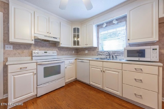 kitchen with white appliances, light hardwood / wood-style floors, white cabinetry, and sink