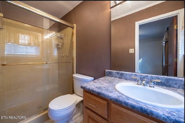 bathroom featuring a textured ceiling, toilet, crown molding, vanity, and an enclosed shower