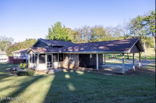 back of property featuring a wooden deck, a patio area, a yard, and a sunroom