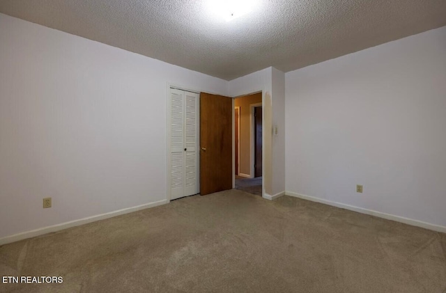 carpeted spare room with a textured ceiling