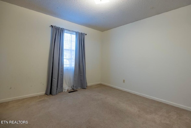 unfurnished room with light carpet and a textured ceiling