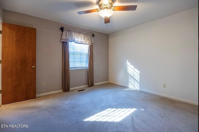 empty room featuring light colored carpet and ceiling fan