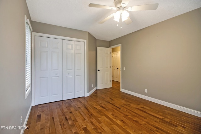 unfurnished bedroom featuring hardwood / wood-style flooring, ceiling fan, a closet, and a textured ceiling