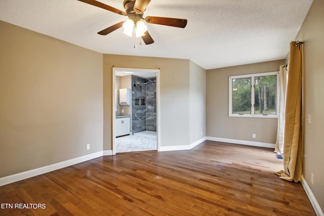 unfurnished bedroom with ensuite bathroom, light hardwood / wood-style floors, and a textured ceiling