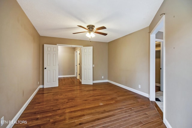 unfurnished bedroom with dark hardwood / wood-style floors and ceiling fan