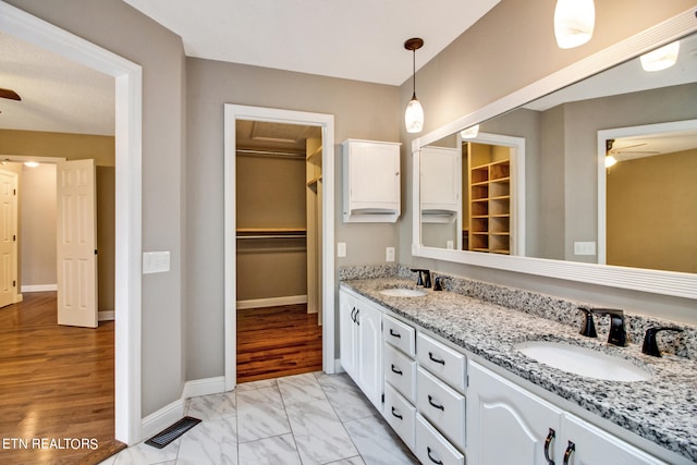 bathroom with wood-type flooring, vanity, and ceiling fan