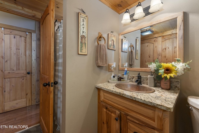 bathroom featuring vanity, toilet, and wood ceiling