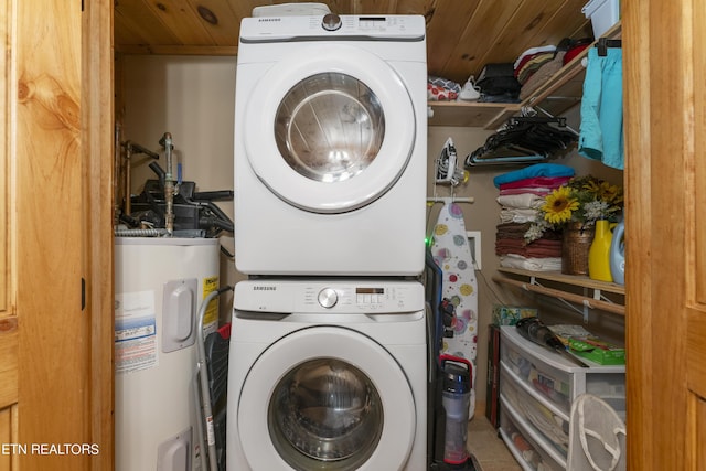 clothes washing area with electric water heater, wood ceiling, and stacked washer and clothes dryer