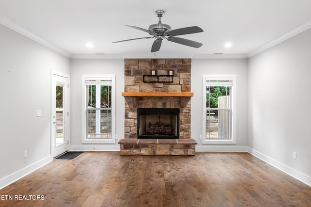 unfurnished living room with wood-type flooring, a wealth of natural light, and a stone fireplace