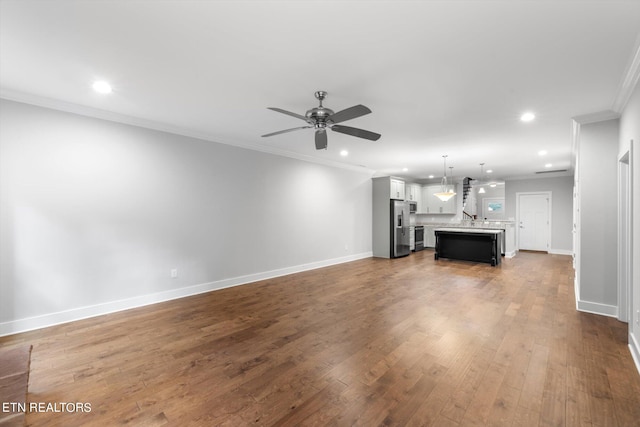 unfurnished living room with crown molding, ceiling fan, and dark hardwood / wood-style flooring