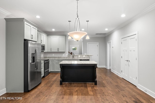 kitchen featuring ornamental molding, a kitchen island, decorative light fixtures, appliances with stainless steel finishes, and dark hardwood / wood-style flooring