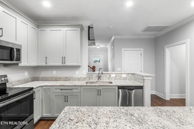 kitchen featuring crown molding, dark wood-type flooring, sink, stainless steel appliances, and light stone countertops